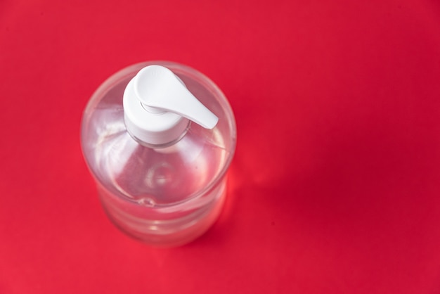 Container with alcohol gel on the red wall