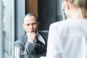 Free photo contemplated businessman sitting in caf�