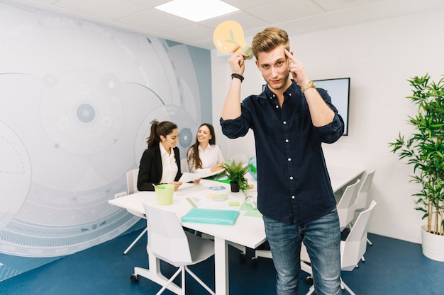 Contemplated young business holding light bulb icon in office