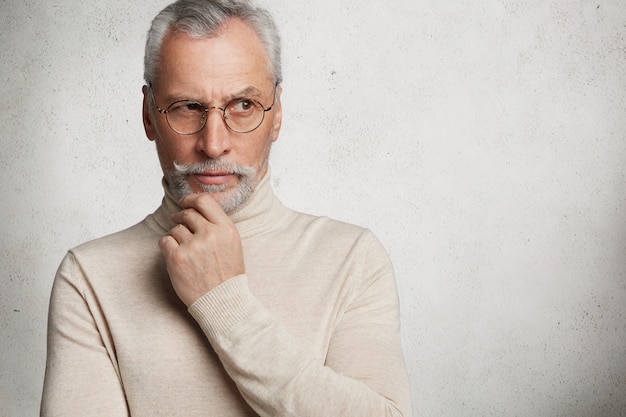 Foto gratuita uomo maturo barbuto contemplativo in occhiali