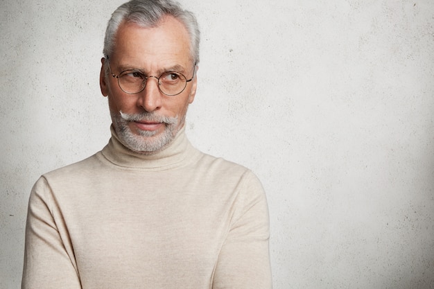 Free photo contemplative bearded mature man in eyewear