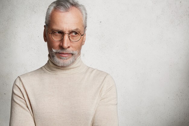 Contemplative bearded mature man in eyewear