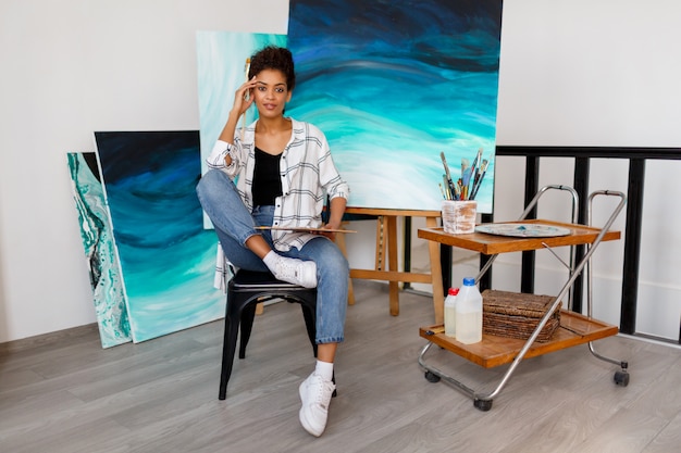 Contemporary art. Talent and creativity. Inspired young black lady working on her ocean abstract artwork.