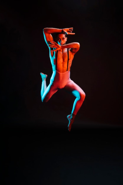 Free photo contemporary male ballet dancer performing in spotlight