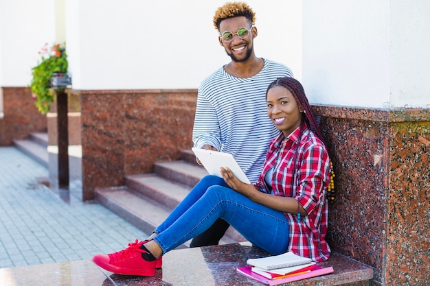 Content black students standing with touchpad