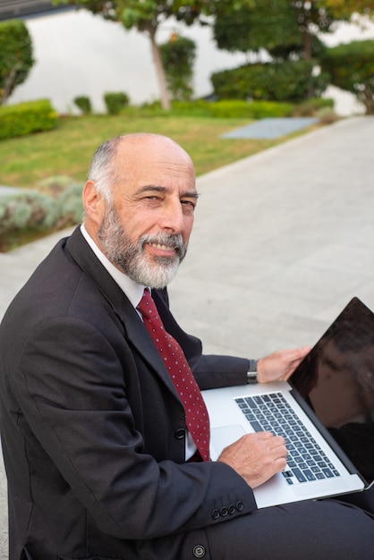 Content businessman using laptop and looking