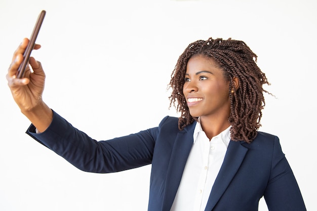 Content businesswoman taking selfie with smartphone