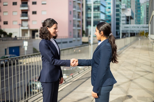 Content businesswomen shaking hands