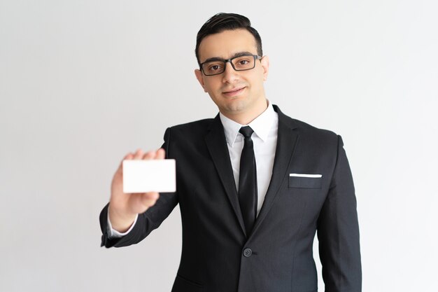Content confident mixed race male lawyer showing business card and looking at camera