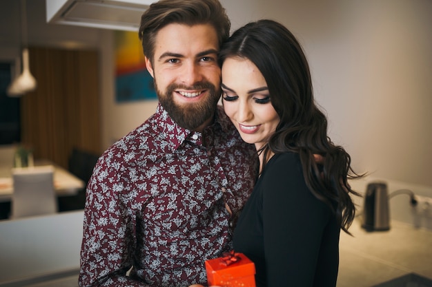 Content couple posing at camera with gift