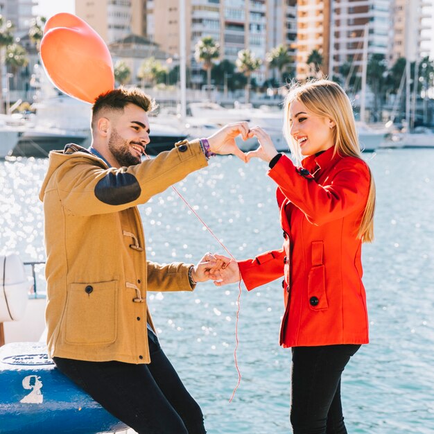 Content couple showing heart from hands