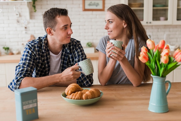 Content couple sitting at table and enjoying tea