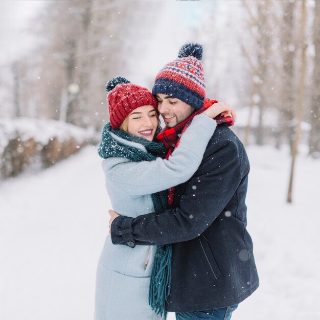 Content embracing couple in snowfall