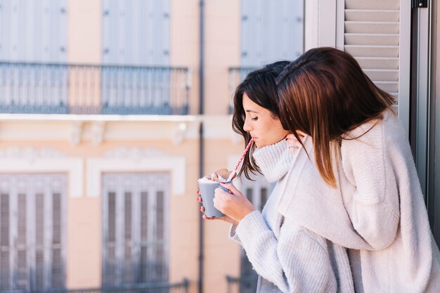 Content embracing women in morning on balcony