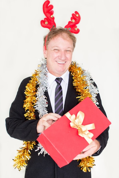 Content funny man in reindeer headband with gift