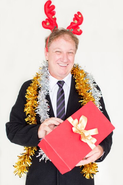 Content funny man in reindeer headband with gift