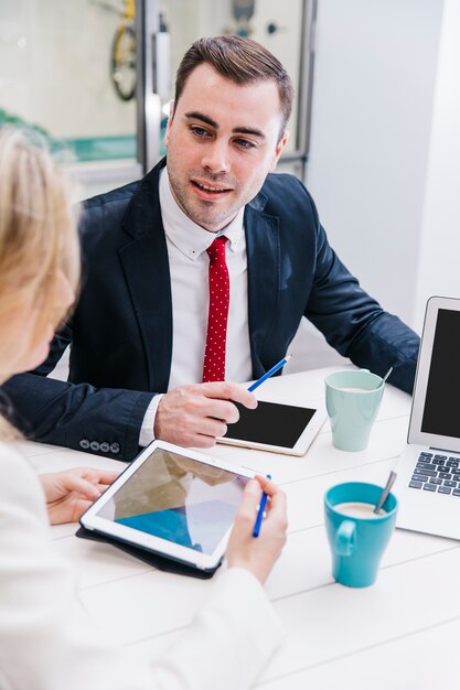 Content man chatting with colleagues at table