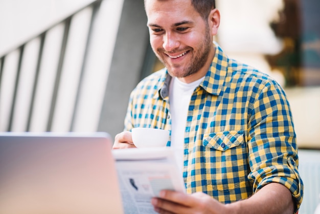 Content man drinking coffee and reading news