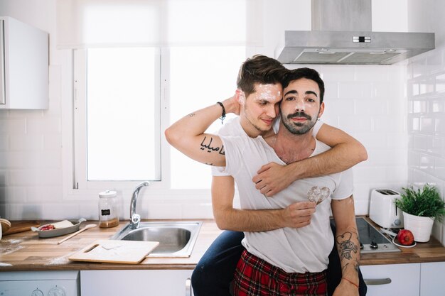 Content men embracing in kitchen