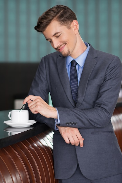 Content Middle-aged Businessman Stirring Coffee
