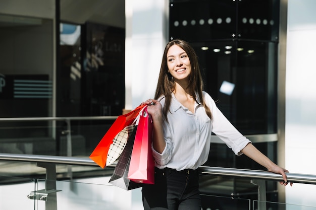 Free photo content model holding shopping bags