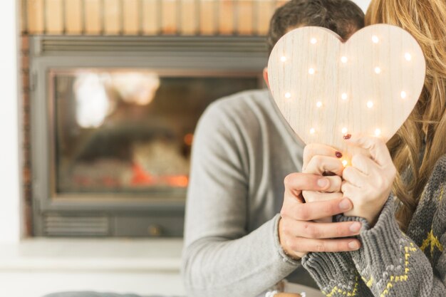 Content people hiding kiss with decorative heart