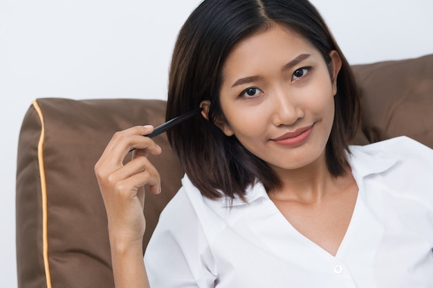 Content Pretty Asian Woman Leaning on Cushion