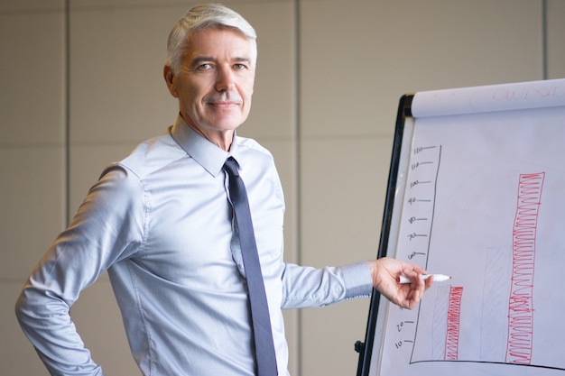 Free photo content senior expert pointing to bar chart