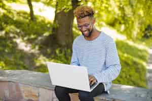 Foto gratuita studente di contenuto in posa con il computer portatile