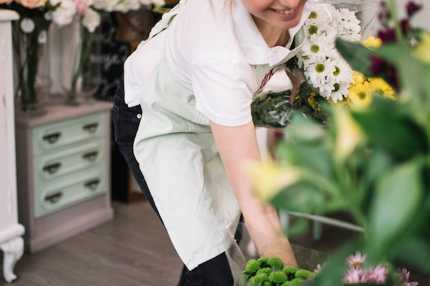 Content woman composing bouquets in shop