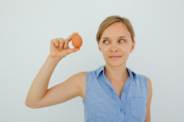 Content Woman Holding Egg With Two Fingers