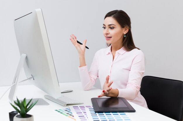仕事中にコンピューターを見て満足している女性