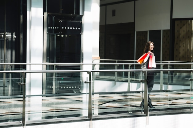 Foto gratuita donna di contenuto che propone nel centro commerciale di luce