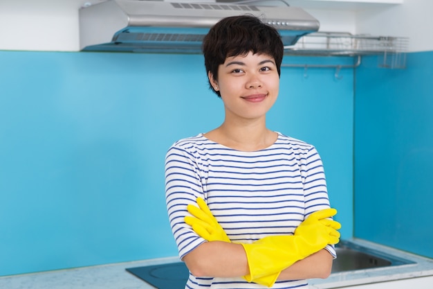 Content Woman in Protective Gloves in Kitchen