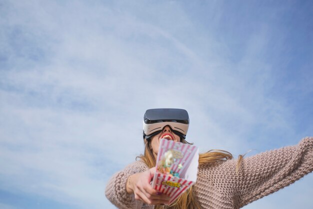 Content woman in VR goggles outside