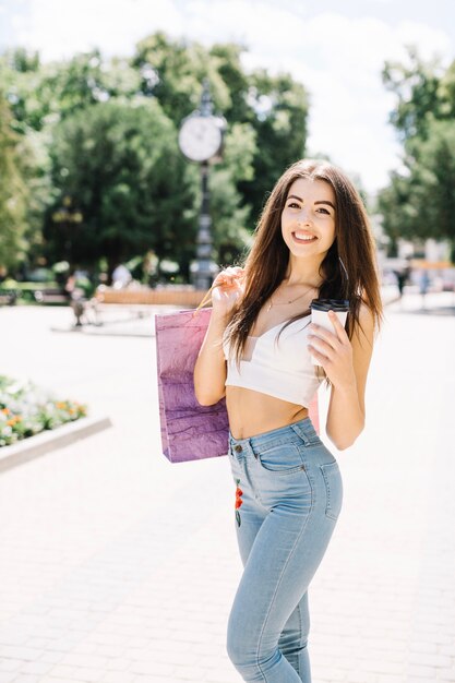 Content woman with coffee and shopping bags