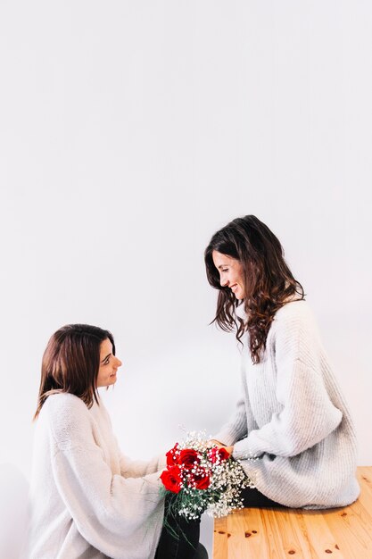 Content women with flowers posing at home