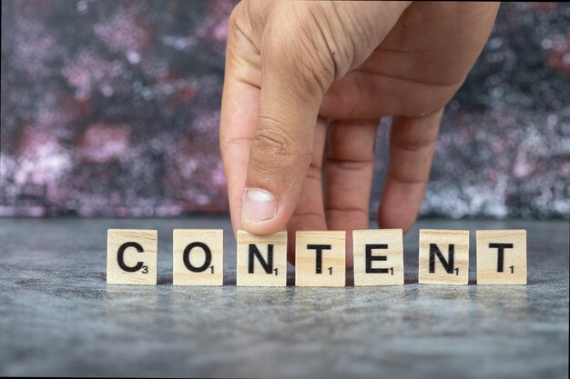 Content writing with black letters on wooden dices on blue background. High quality photo