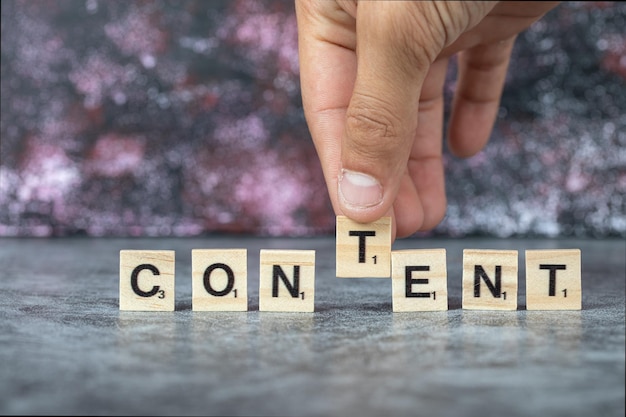 Content writing with black letters on wooden dices on blue background. High quality photo