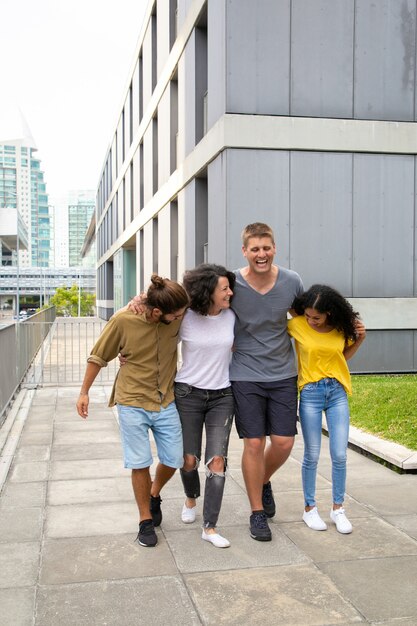 Content young friends walking on street together