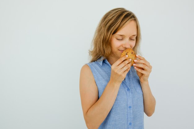 Content Young Woman Smelling Tasty Cookie
