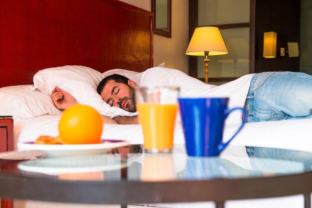 コンチネンタルブレックファストとホテルで寝る男