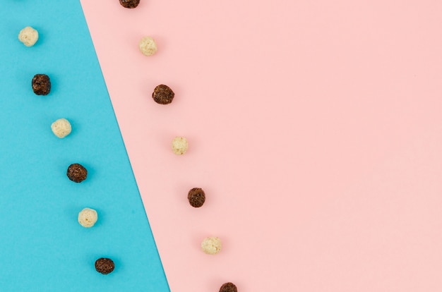 Free photo contrasted background with cute coloured cereals