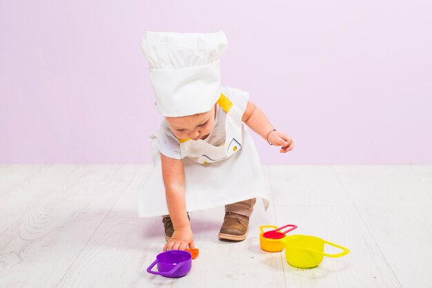 Cook child playing with toy dishes 