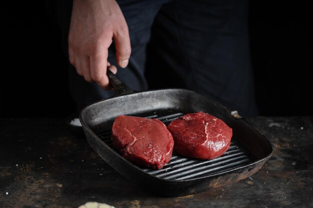 Cook cooking fresh peace of meat on board Dark background Cooking concept