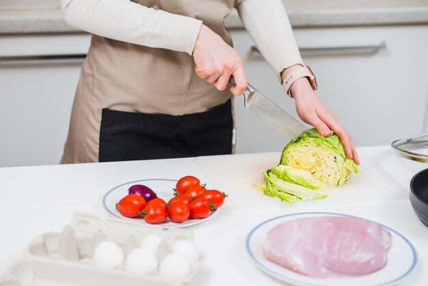 Cook cutting cabbage on board