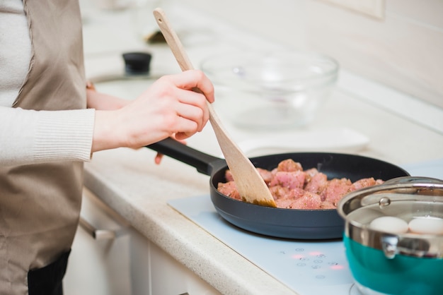 Cook frying meat at kitchen