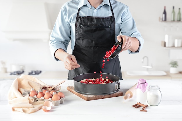 A cook on a rustic kitchen. The male hands with ingredients for cooking flour products or dough, bread, muffins, pie, cake, pizza