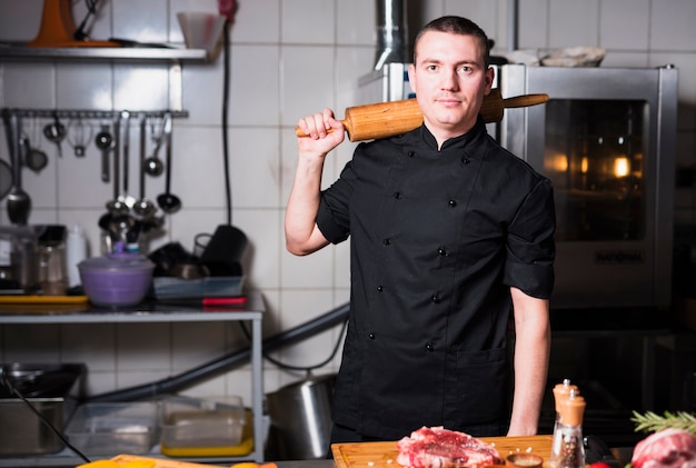 Cook standing with rolling pin in hand