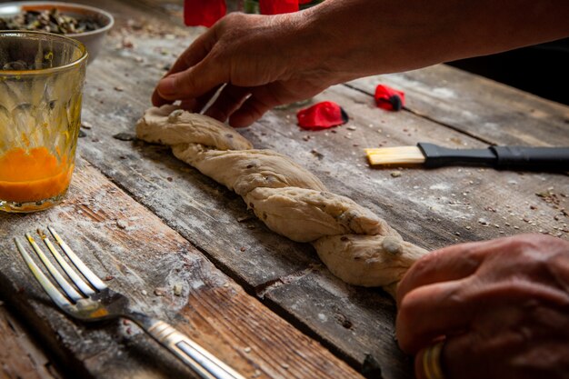 Cook stretching dough with hands on wooden table